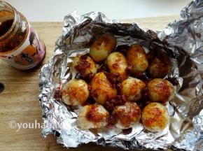 用工具把小土豆都取出来（烫手），表面划上十字刀，继续放回锡纸中，表面上淋上香菇酱，根据自己喜欢的口味用，我用的是奥尔良口味的香菇酱，表面撒一点盐