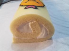 5. 在蛋糕片一边垫一块小毛巾，两手抬起另一边轻轻按压边缘，然后提起来速度卷起来，一个蛋糕卷就卷起来了。