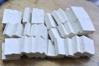 2、将豆腐切成1cm宽，4cm*4cm大小的片状