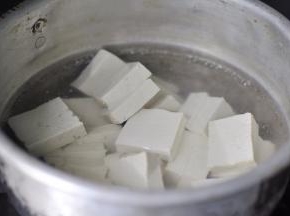 3、切好的豆腐放入开水锅中煮沸