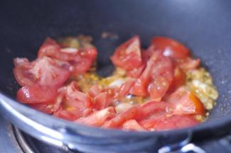 11、将切好的番茄放入锅中翻炒。