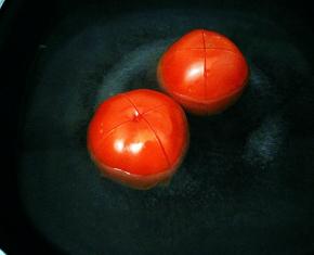 番茄划十字刀，放入热水中烫个一分钟，去皮切小丁。