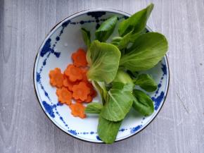 将小油菜和胡萝卜洗净，切片后用模具刻出花形（直接圆片也可以）