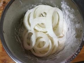 切好的洋葱圈放入干粉内。均匀让它粘好粉。