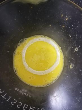 粘好裹粉的洋葱圈，放入鸡蛋液中，溜一圈。