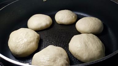 发酵后的生胚比原先大1/3，盖上锅盖，开启小火烙。