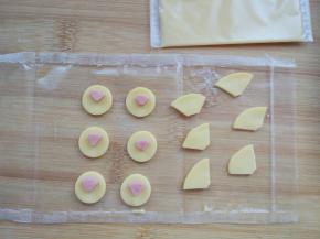 用小刻刀将奶酪片和火腿片切出眼睛、嘴和鼻子的轮廓