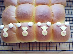 将旺仔小馒头用融化的黑巧克力黏在面包上，充当耳朵，将奶酪和火腿放在脸部恰当位置