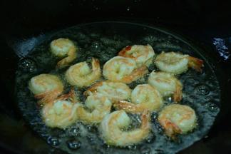 锅中倒入适量菜籽油，等油熟烫将虾下入锅中，炸至金黄。关火捞出沥干油待用。