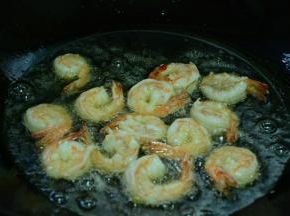 锅中倒入适量菜籽油，等油熟烫将虾下入锅中，炸至金黄。关火捞出沥干油待用。