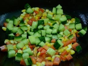 接着再加入玉米粒和黄瓜翻炒出香味。