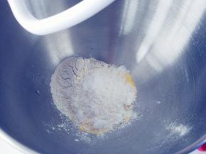 将玉米面和高筋粉、细砂糖混合，倒入厨师机搅拌桶里，安装好和面钩