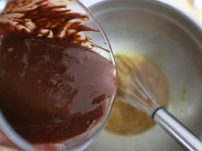 等巧克力黄油液还剩有余温的时候，倒入鸡蛋盆子里。一边倒入，一边快速搅拌均匀
