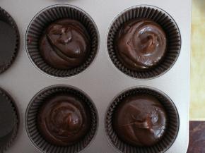 将面糊挤入纸杯模具中。七分满即可