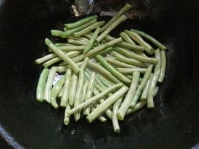 起锅倒油（比平时用量稍多些），下豆角煸炒。
