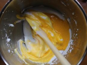 然后将蛋黄倒入到蛋白盆子里。用翻拌的手法翻拌均匀