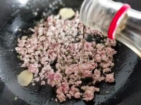 再加入肉糜，小火炒至变色后加入料酒。