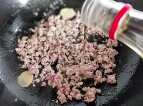 再加入肉糜，小火炒至变色后加入料酒。