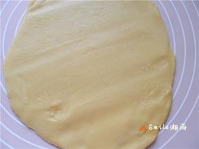 塔皮取出，待稍软后，在案板上铺点面粉，用面棍擀成6寸批萨盘大小。