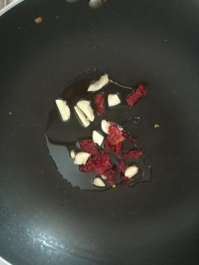 热锅凉油，放入大蒜和辣椒煸香。
