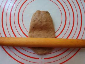 取一个面剂，整形成椭圆形，按扁。擀面杖以中间为轴，先擀下部，再擀上部。