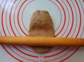 取一个面剂，整形成椭圆形，按扁。擀面杖以中间为轴，先擀下部，再擀上部。