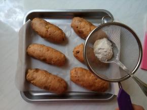 发酵好后，面包表面喷少许水，筛入面粉（高、低粉都行）。用小勺变敲筛网，边筛下面粉，这样不会弄的面粉到处都是。