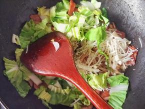 把青菜和金针菇倒入继续炒