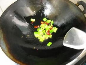 锅中余油，爆香干红椒，倒入青辣椒，炒匀。