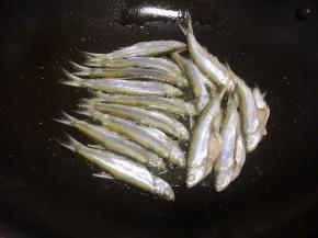 锅里放入适量的油，把腌好的小鱼加入锅里煎