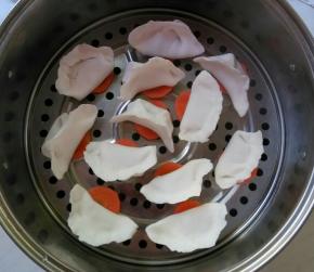 饺子下垫胡萝卜片。水开后再放入蒸屉。十分钟左右即可关火。