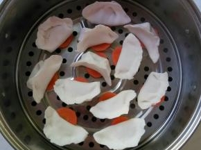 饺子下垫胡萝卜片。水开后再放入蒸屉。十分钟左右即可关火。