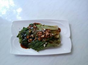 把生菜码在盘中，撒上蒜末，将热酱汁浇在蒜末上。