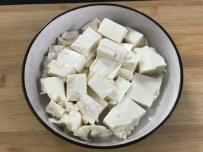 内脂豆腐冲洗一下后切成块，放入盘中。