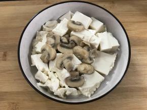 把蘑菇放在豆腐上面。