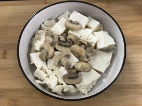 把蘑菇放在豆腐上面。
