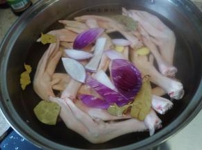 将鸭掌洗干净冷水下锅，放入葱姜蒜、洋葱、料酒过水后用热水洗干净备用