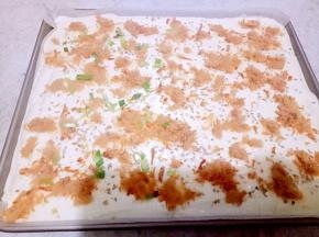 把蛋糕糊倒入阳晨12.8寸烤盘里，震几下。撒上肉松和葱花。