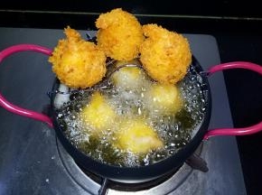 锅中放入适量油烧热，用筷子放入油锅中周围有密集小泡时，下入虾球，小火炸至金黄