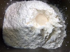 一角放入盐，粉堆中间挖个坑把酵母放进去再埋起来