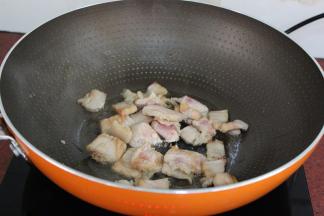 热锅，倒油，爆炒腌制好的猪肉至油脂出来；