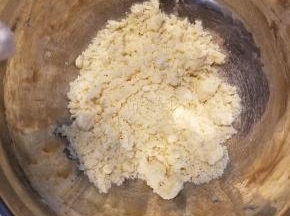 用手充分抓匀，使黄油和面粉混合，抓匀的面粉黄油呈现粗玉米粉的状态