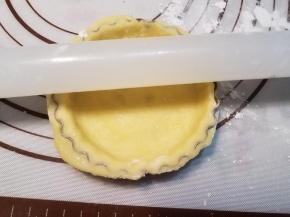 用擀面杖在挞模上滚过，切断多余的面皮。依次做好剩余的挞皮