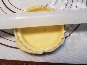 用擀面杖在挞模上滚过，切断多余的面皮。依次做好剩余的挞皮