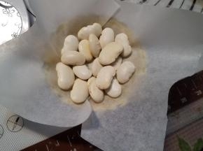 在挞皮底部铺一张裁剪好的油纸，放上一些豆子（防止挞皮烤的时候鼓起来）