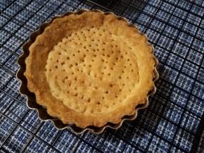 放入预热好160℃的烤箱，烤15分钟左右，待挞皮成型后，拿掉油纸和豆子，继续烤10分钟左右，使挞皮整体变成金黄色。冷却备用