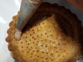 在凉透的挞皮表面刷一层薄薄的黄油，再在表面挤上一层栗子奶油
