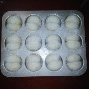 取出烤盘，烤箱上下火200度预热，在面包坯上筛一层高筋面粉。