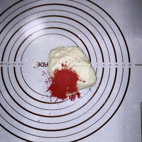 取一小半的面团，加入红曲粉揉匀。