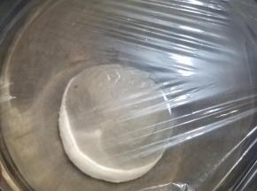 取出搅拌好的面团，揉成一块光滑的面团，装入一个小盆中，盖上保鲜膜密封，进行一次发酵